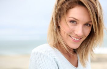 A young woman smiling at the beach.