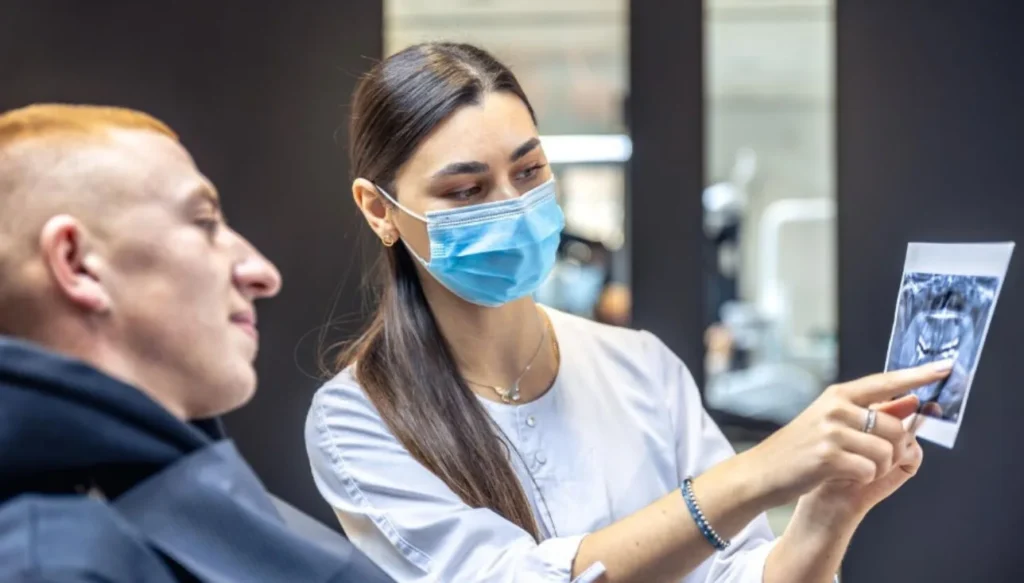Dentist explaining dental X-ray to patient during consultation